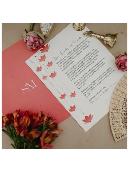 A beautifully designed wedding thank-you note for guests, laid out with flowers and a traditional handbell. This shows how we carry the design theme through to the very end.