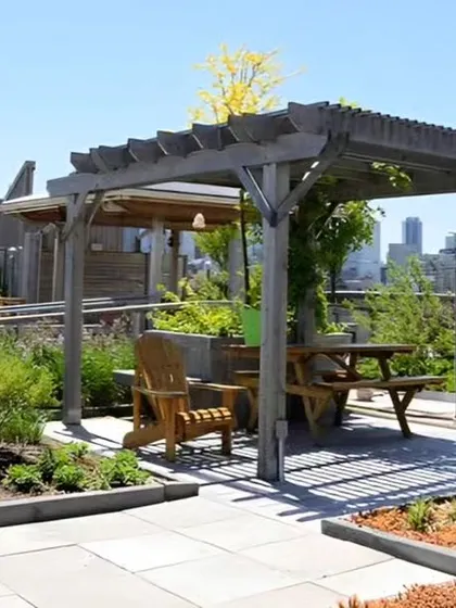 Another view of a rooftop garden with a pergola, planters, and outdoor furniture, creating a functional and beautiful living space.