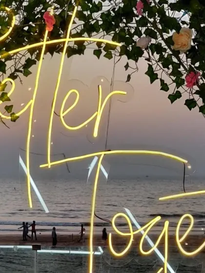 A close-up of the "Better Together" neon sign we used for an engagement party. Set against a floral arch with the sunset in the background, it creates a perfectly romantic photo opportunity.