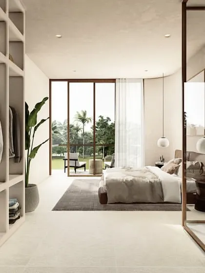 A view from the walk-in closet into the bedroom of a Pavilion home. The open-plan design creates a seamless flow between the dressing area, sleeping space, and the outdoor view, enhancing the sense of spaciousness.