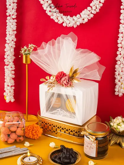 A slightly different angle of the premium white Diwali hamper, showing more of the surrounding festive decor.