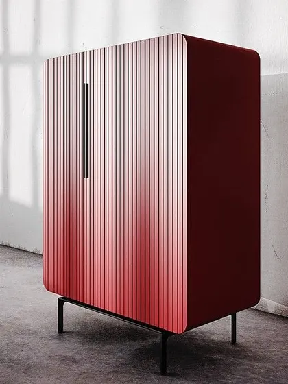 The silhouette of this cabinet gently bends over the corner, while the fluted facade creates a uniform pattern. Shown here in a striking ombré red, this piece features soft-closing mechanisms for maximum comfort and no slamming noise.