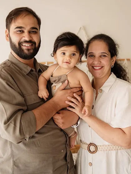 A proud family portrait. This shot shows a happy family of three, smiling and comfortable in our boho-themed studio setup.