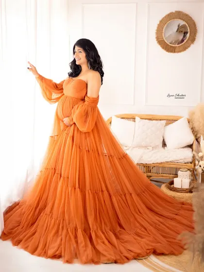A beautiful profile shot by the window, with the natural light making the orange gown glow.