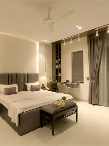 For a Noida client, I designed this master bedroom with a sleek monochrome palette. The PU-finished bed back with soft cove lighting and hanging lights creates a perfect nighttime glow.