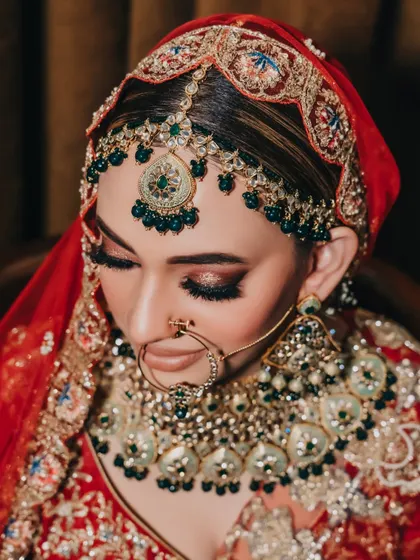 A close-up portrait focusing on the bride's intricate matha patti and stunning eye makeup. We love to capture the details that complete the bridal look.