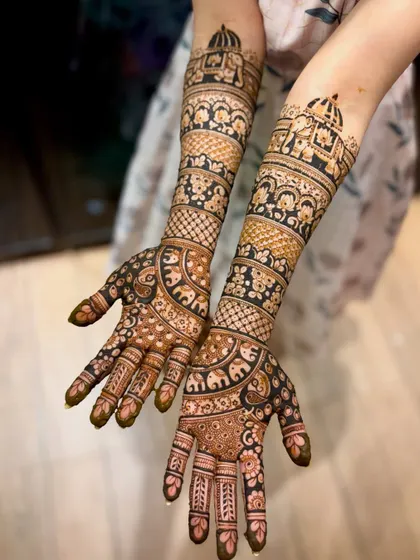 This design features elephant and peacock motifs, classic symbols of good fortune and beauty in bridal mehendi.