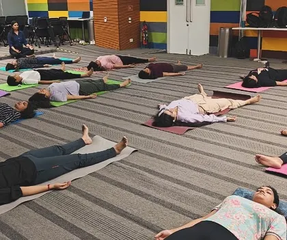 A wide shot showing the scale of the corporate yoga and sound healing session. Even in a large group, each individual can find their own personal space for relaxation and introspection.