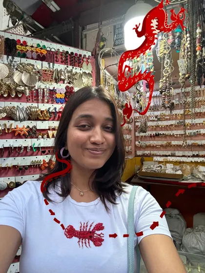 A selfie at a jewelry shop, with a red dragon and lobster doodle for a quirky, random touch.