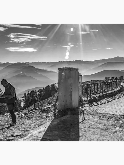 Morning sun breaks over the mountains in Himachal Pradesh. I captured this scene to show the contrast between the quiet moment shared by the two figures and the immense, sun-drenched landscape behind them.
