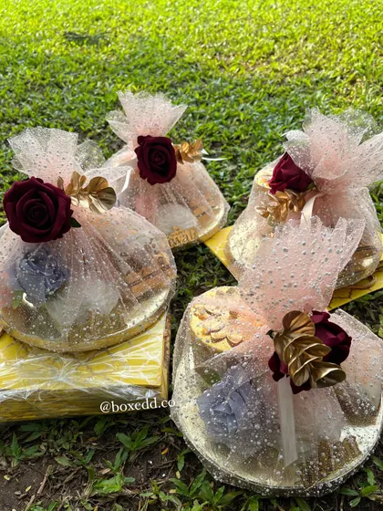 A collection of our festive gift platters, beautifully wrapped in sparkling pink tulle and adorned with deep red roses. These are perfect for Diwali, weddings, or any grand celebration.