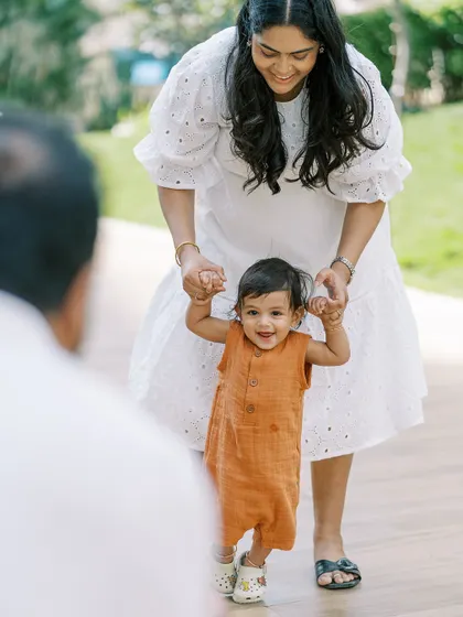 A baby taking his first steps towards his father. A precious milestone captured in a beautiful outdoor setting.