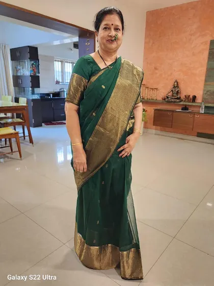 This customer looks absolutely regal in our dark green Maheshwari silk cotton saree with its grand gold border. Perfect for a family function.