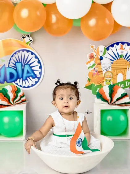 Celebrating Independence Day with our littlest patriot. Dressed in white and holding the flag, she looks absolutely adorable in this tricolor themed setup.