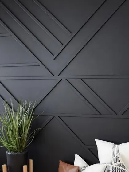 A duplicate of image 104, showcasing a dramatic accent wall with geometric molding in a dark finish.