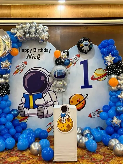 A full shot of the space-themed stage, including the backdrop, balloon arch, and a balloon pillar with the number '1'.