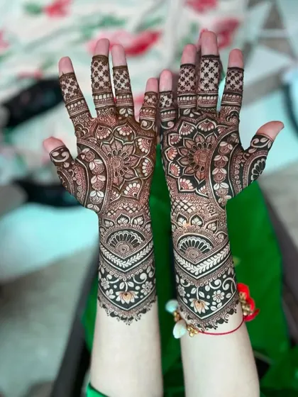 A classic Indian mehndi design with full coverage. The pattern includes floral mandalas on the palms and detailed bands covering the arms.