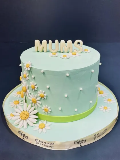 A lovely mint-green cake covered in daisies for "Mums," a simple and sweet way to show your love.