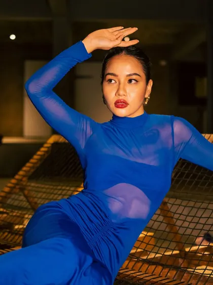 A duplicate image for context. A striking editorial look featuring a bold red lip and clean skin against a vibrant blue dress.