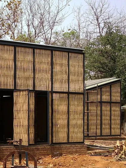 A view of the modular units at the Artist Residency during construction. The lightweight steel frame and bamboo exoskeleton are clearly visible, showcasing the core components of this design that prioritizes natural materials and inside-out living.