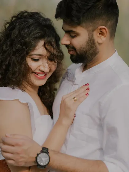 A close-up shot capturing a gentle, happy moment. The soft focus on the background emphasizes the couple's connection and the bride's joyful expression.