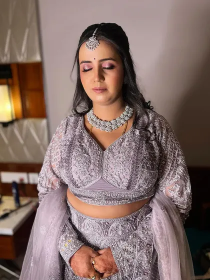 A dreamy reception look in a lavender lehenga. The makeup features soft pink and purple eyeshadow with a subtle lip, paired with diamond jewelry for a touch of sparkle.