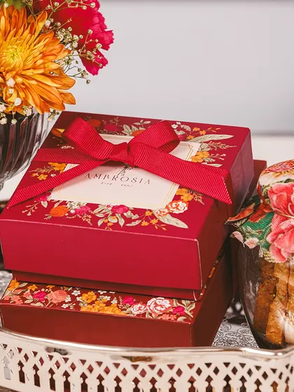 Treat your loved ones to the finest this Diwali. Our hampers are crafted to perfection, like these beautifully boxed sweets tied with a rich red ribbon.