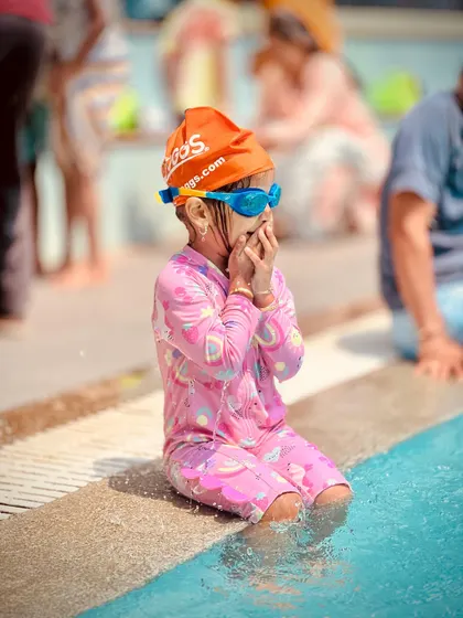 A series of candid shots showing a young swimmer's journey of getting comfortable at the pool's edge. From happy claps to playful splashes, it's all part of the learning process.