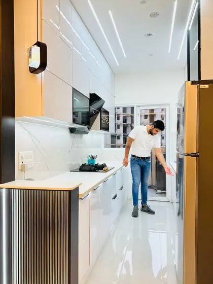 A bright and airy modular kitchen at JM Florence. The all-white theme, combined with glossy finishes and profile lighting, makes the space feel larger and more open.
