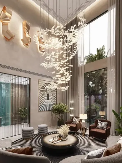 We bring nature indoors as an element of luxury in this double-height drawing room. A magnificent chandelier mimics a flock of birds in flight, complemented by large windows that flood the space with natural light, creating a seamless connection between the opulent interior and the lush exterior.