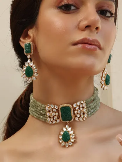 A modern choker from the Emrosia collection, featuring a unique pendant and carved emeralds.