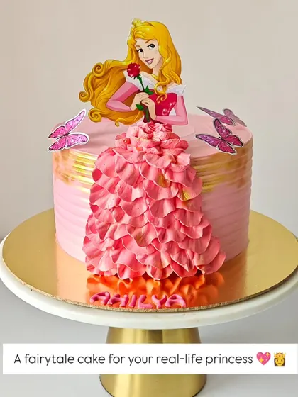 A fairytale cake for a real-life princess. This design features Princess Aurora with a beautiful gown made of pink buttercream ruffles, creating a dreamy and elegant look for a special birthday.