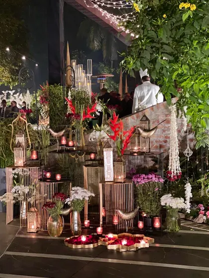 A corner bursting with decor elements: tiered stands, candles, and a mix of red and white flowers, creating a rich, layered look.