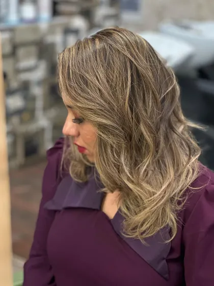 The side profile shows the soft waves and beautiful blonde tones.