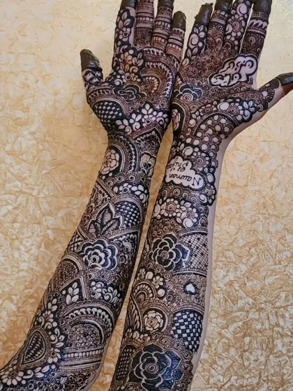 This is a full bridal design that goes all the way up the arms, combining bold floral motifs with delicate, intricate patterns. I also included the names Nauman and Shifa in the palms to make it a unique part of their story.