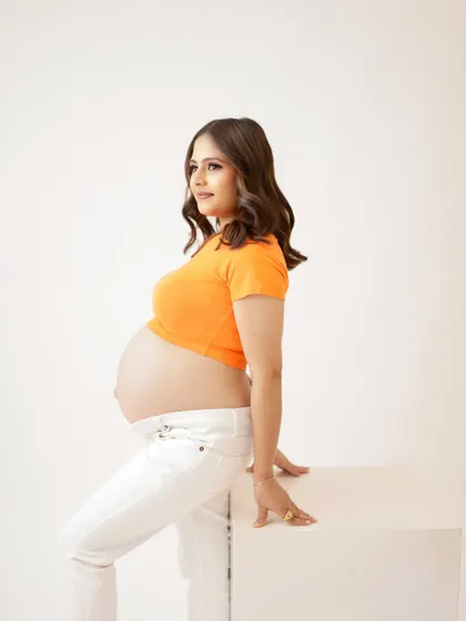 A duplicate of image 294, this casual and vibrant portrait in an orange crop top and white pants is full of life.