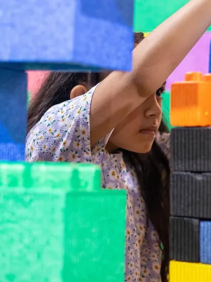Peeking through a fortress of giant blocks. Kids love the challenge and fun of building structures they can actually play in.