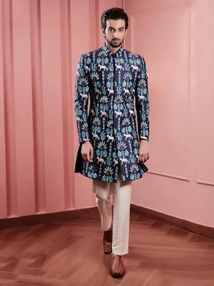 A full-length shot of our navy blue Indo-Western jacket with a striking animal and foliage print. Paired with classic white trousers, it's a modern and fashionable statement.