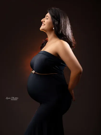 The pure joy of pregnancy captured in a simple, beautiful profile shot. The black gown provides a perfect silhouette.