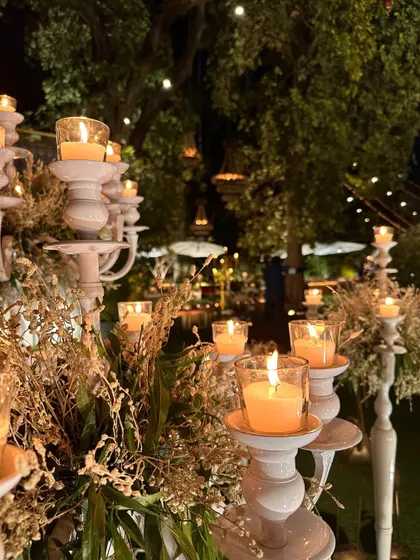 Golden corners. A close-up of white candelabras lit for an evening event, with dried floral accents.