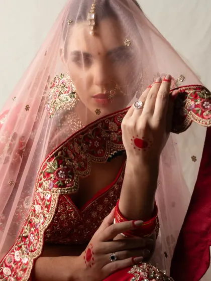 A creative bridal portrait, with the bride's face partially obscured by her veil. This artistic shot plays with layers and focus to create a sense of mystery and elegance.