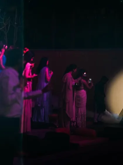 A dramatic, spotlit shot of the bride during her Sangeet performance. The lighting creates a theatrical and captivating image.