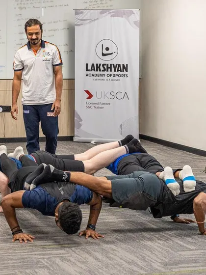 A fun, practical team-building exercise during a UKSCA course, demonstrating creative ways to think about bodyweight strength and conditioning.