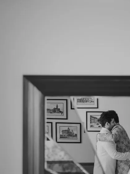 A tender hug between family members, captured in a mirror's reflection. A moment of love and support before the big step.