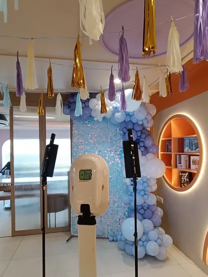 A view of a party setup that includes a photo booth against a blue shimmer wall. This shows that we can provide interactive elements like photo booths to complement our decor and enhance the guest experience.