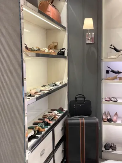 A detailed view of the elegant, back-lit shelving used for displaying women's footwear and accessories.