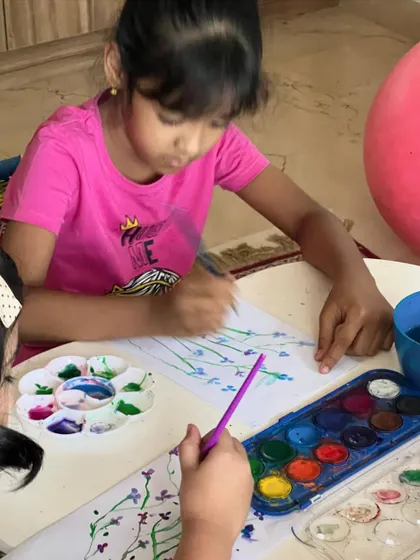 Two artists working side-by-side on their floral paintings. We encourage a calm and focused atmosphere where kids can learn from each other.