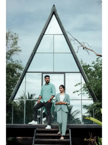 A stylish couple posing on the steps of a modern A-frame house. Their coordinated outfits and the unique architecture create a chic and contemporary pre-wedding photograph.