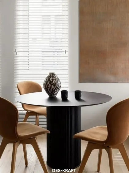 This dining setup combines a sleek black table with warm, tan-colored chairs, creating a sophisticated contrast that is both modern and inviting.
