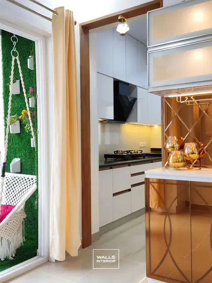 A compact and glamorous bar unit designed next to the balcony. It features gold-tinted mirror cabinets, a wine glass rack, and integrated lighting, perfect for entertaining.